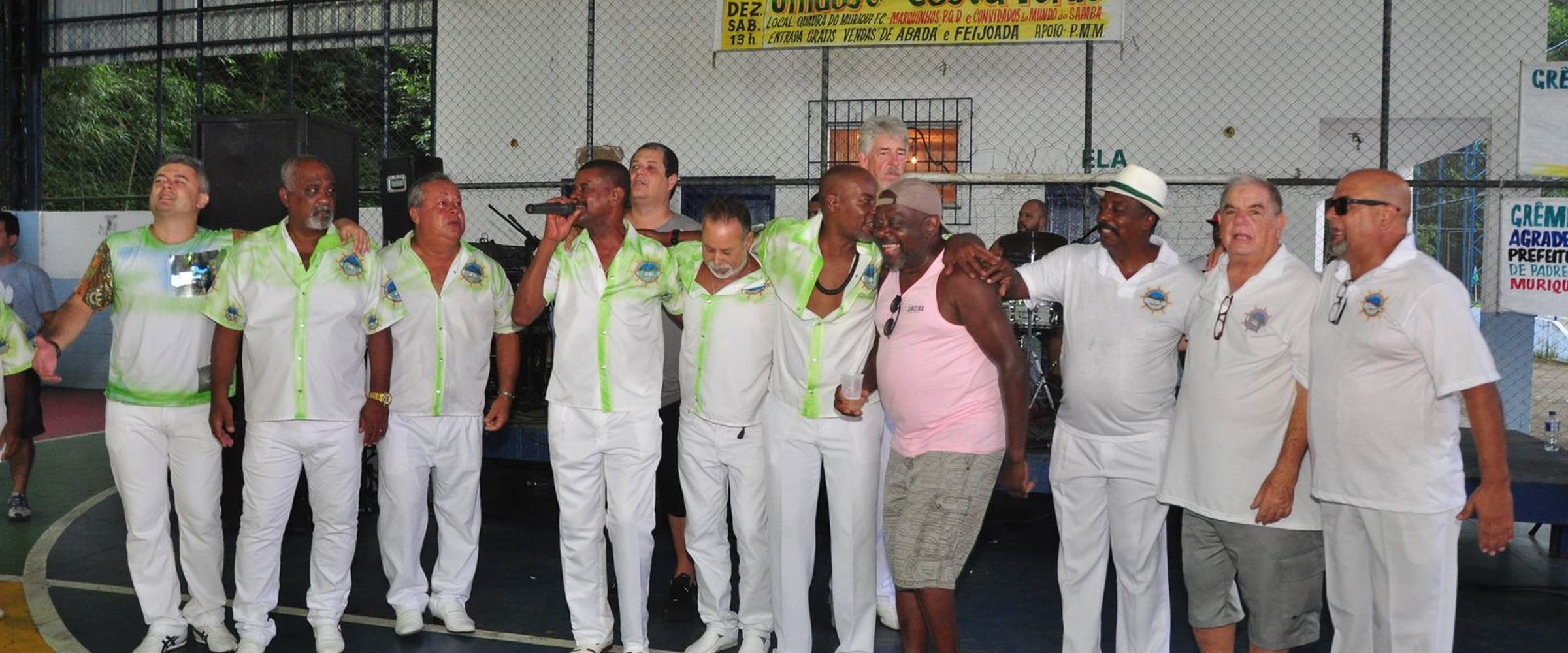 Integrantes da GRESUCV Unidos da Costa Verde reunidos cantando em evento na quadra do Muriqui