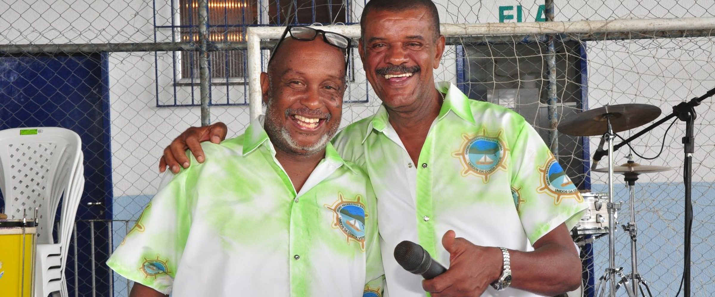 Marquinho PQD e diretor da GRESUCV Unidos da Costa Verde sorrindo em evento na quadra do Muriqui